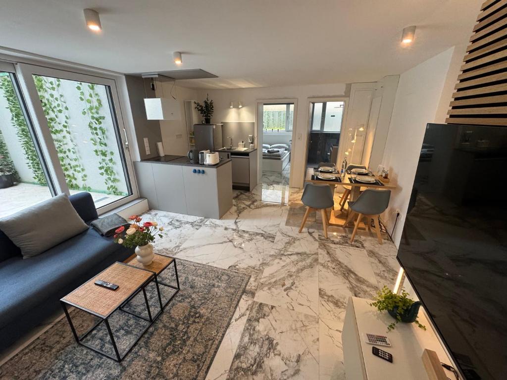 a living room with a blue couch and a kitchen at Lichtdurchflutete Suite mit Lichthof in Karlsruhe