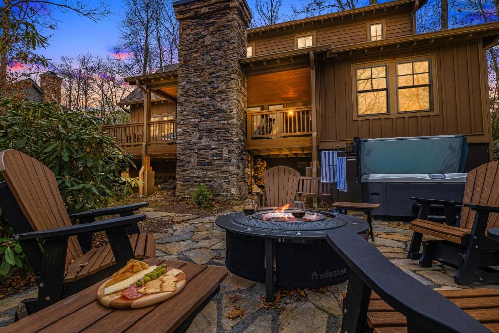 a patio with a fire pit in front of a house at Timberwalk Cottage - Blowing Rock Luxury Cabin with Hot Tub and Fireplaces in Blowing Rock