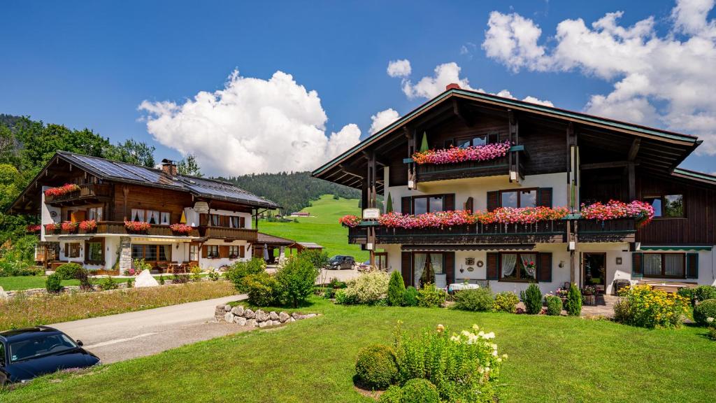 a house with flower boxes on the front of it at Gästehäuser Schwemmbauer in Reit im Winkl