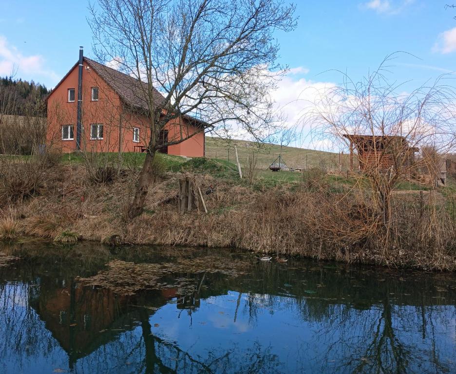 an old red house next to a river at Chalupa Nad Hladinou in Teplice nad Metují