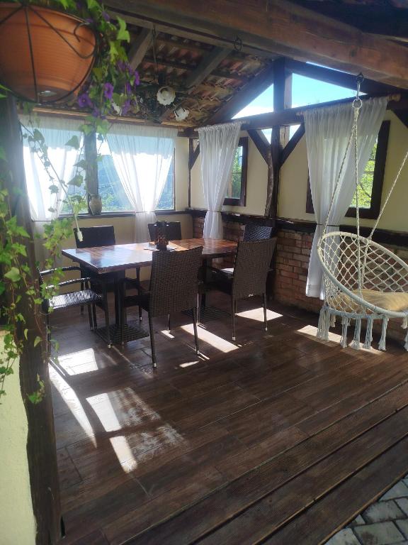 a dining room with a table and chairs on a wooden deck at Studio Lanisa in Kanal