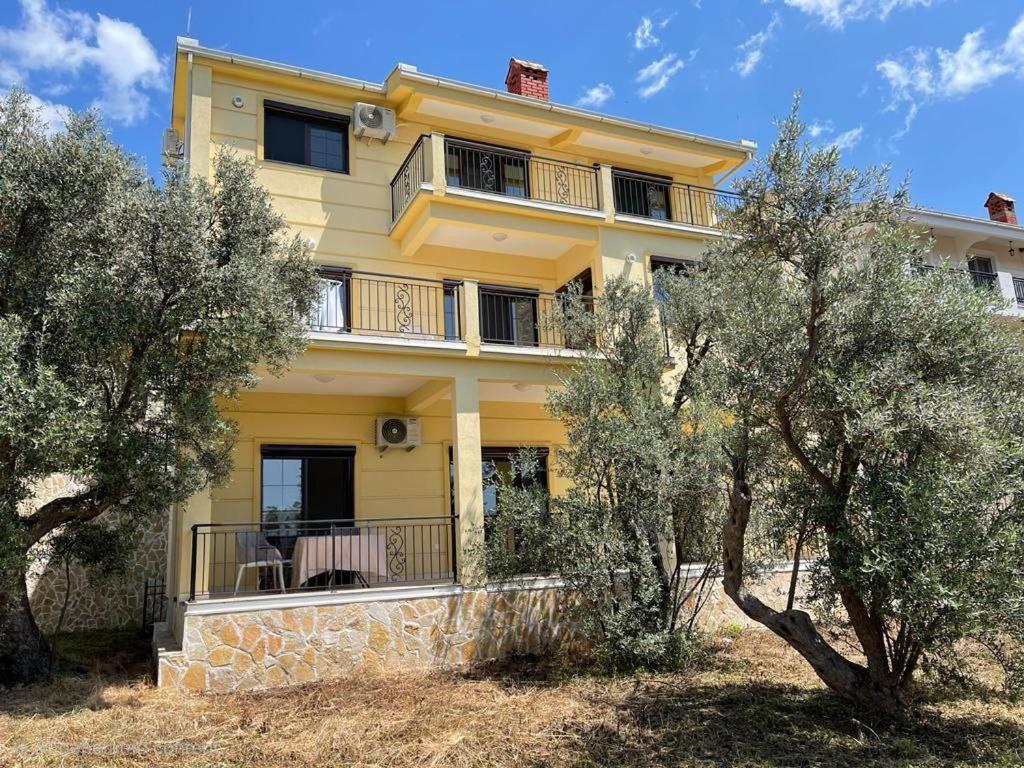 a yellow house with trees in front of it at Villa in Čeluga