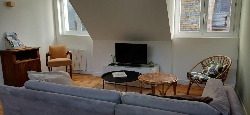 a living room with a blue couch and a tv at Appartement BZH in Plougastel-Daoulas