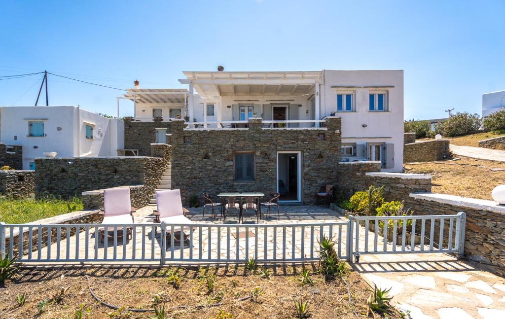 a house with two chairs and a table in front of it at Popis Home in Faros
