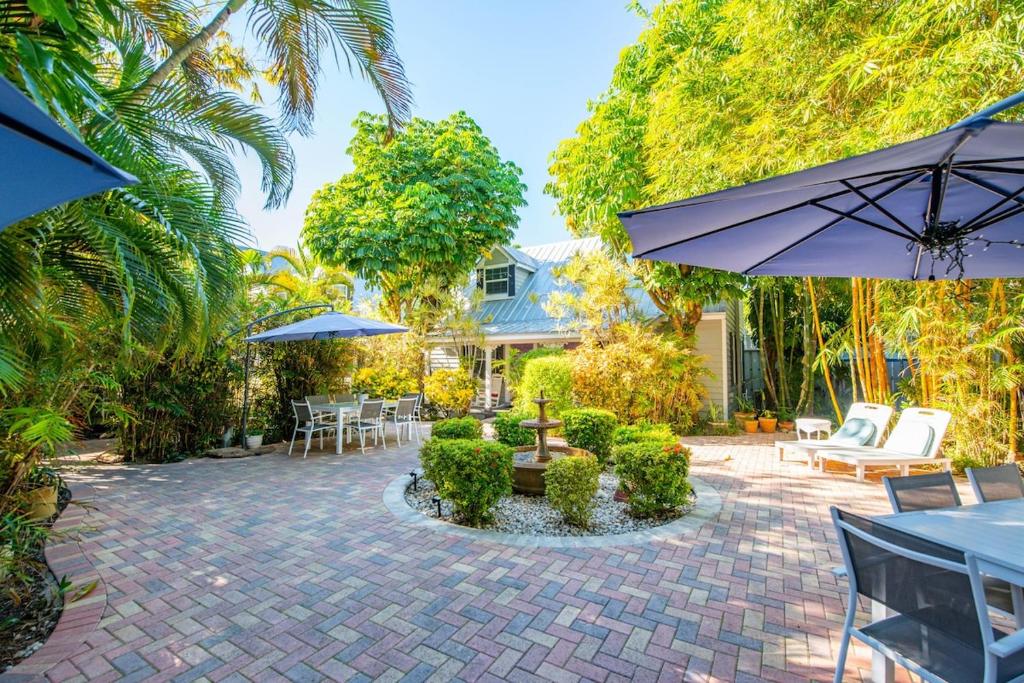 a patio with an umbrella and chairs and tables at Andros Suite in Key West