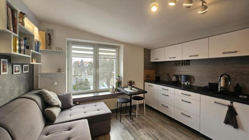 a living room with a couch and a table in a kitchen at Studio w kamieniczce in Konstantynów Łódzki