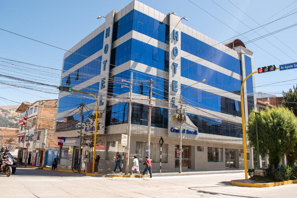 ein blau-weißes Gebäude in einer Stadtstraße in der Unterkunft Hotel Sucali in Huaraz