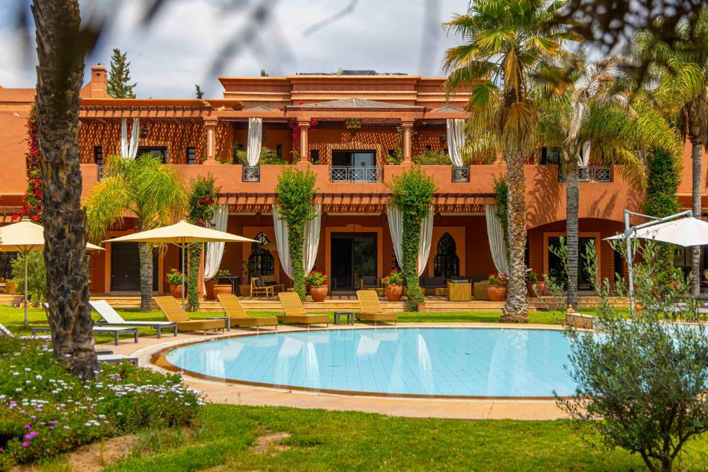 a resort with a swimming pool in front of a building at Mila Dyafa in Oulad Akkou