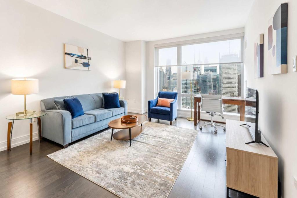 a living room with a couch and a tv at Luxury Apt with Gym & Pool in New York
