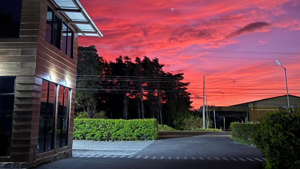 a building with a red sunset in the sky at Rainbow Valley Lodge Costa Rica in Monteverde Costa Rica