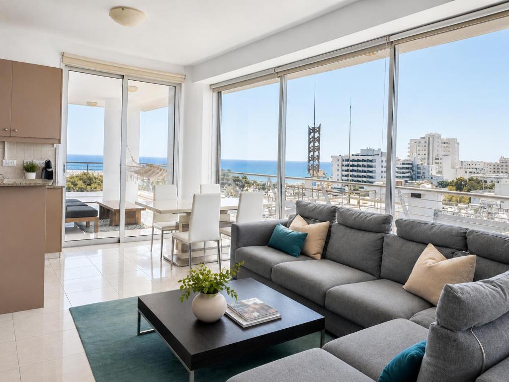 a living room with a couch and a table at TOP RATED - PREMIUM Seaview 2-BDR-Apt in tallest building in Larnaca - 2 min Walk to Beach in Larnaca