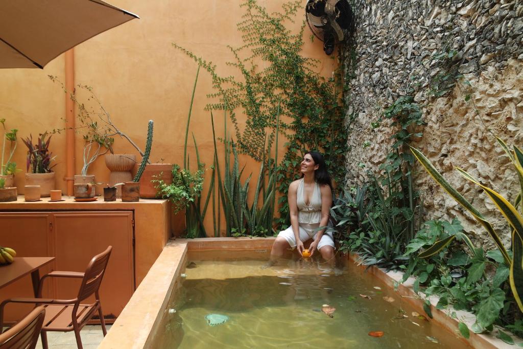 a woman sitting in a pool of water at Kuka y Letras in Mérida