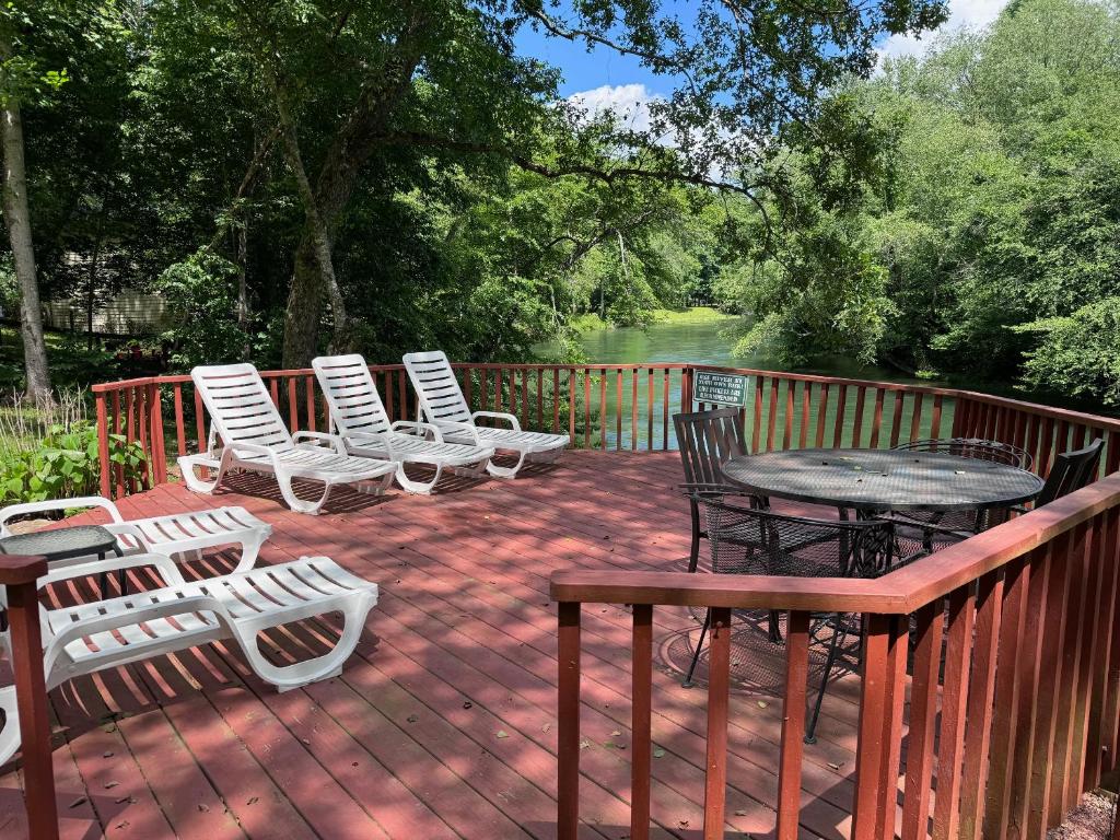 a deck with chairs and a table and a table and chairs at Bigfoots River Retreat in Mineral Bluff