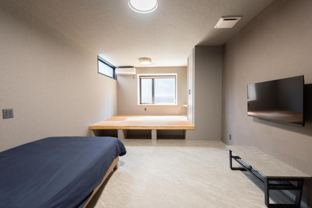 a bedroom with a bed and a tub and a television at HOTEL PG3 - Vacation STAY 46492v in Habu