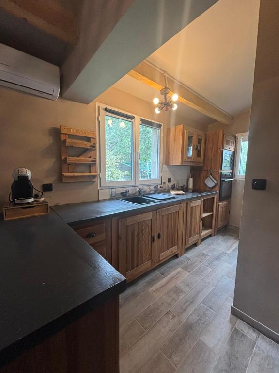 a kitchen with wooden cabinets and black counter tops at A fontanille in Magalas