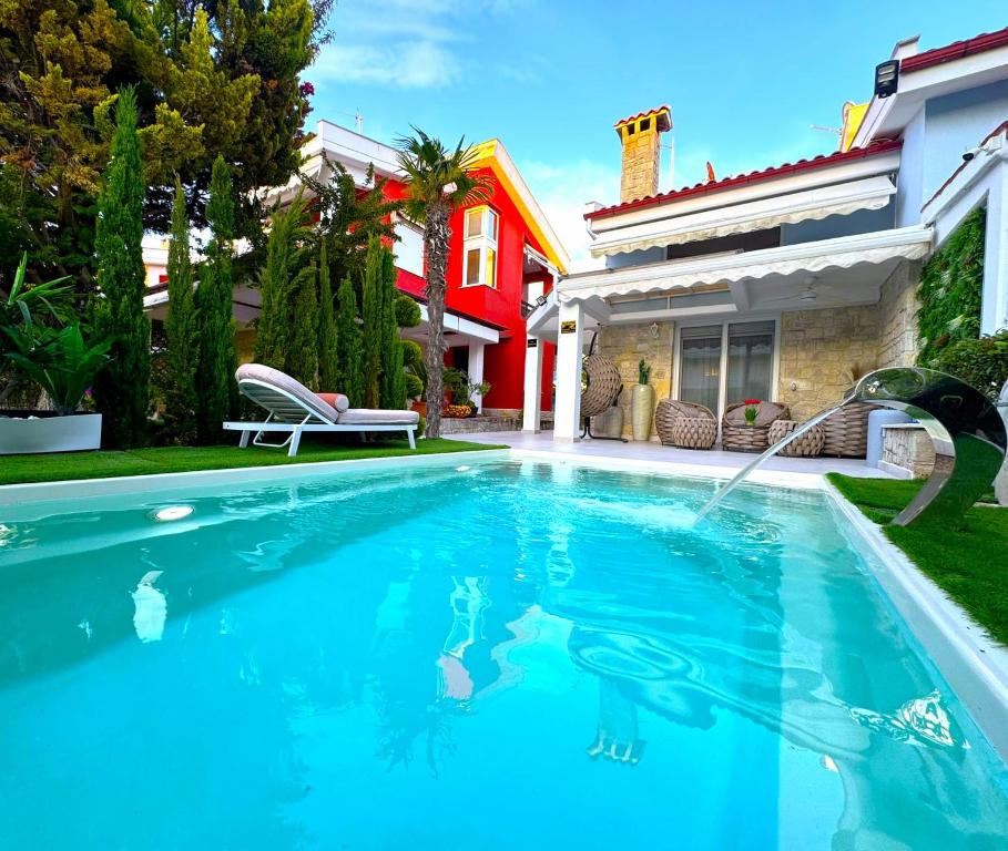 a swimming pool in front of a house at villa MEDITERAN in Pefkochori