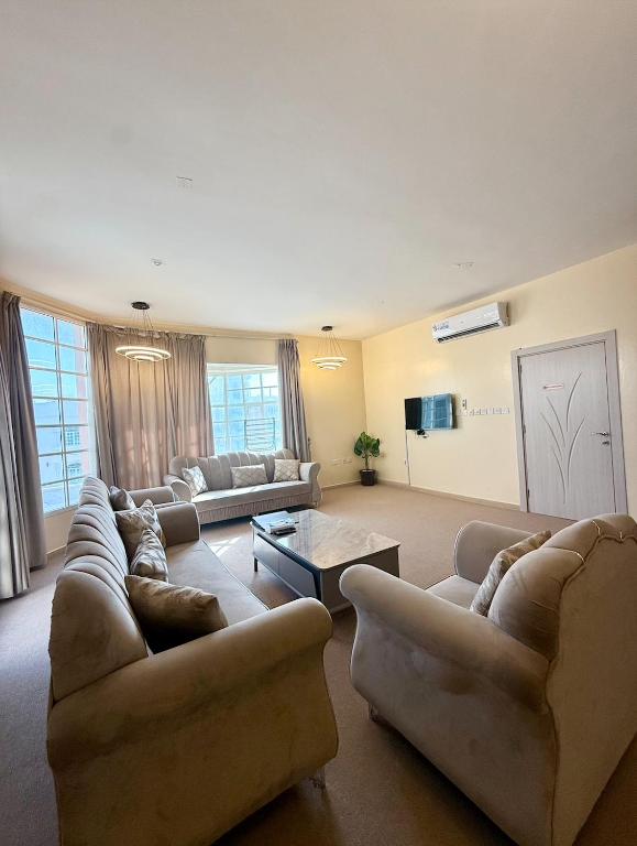 a large living room with couches and a tv at Deluxe Apartment in Muscat