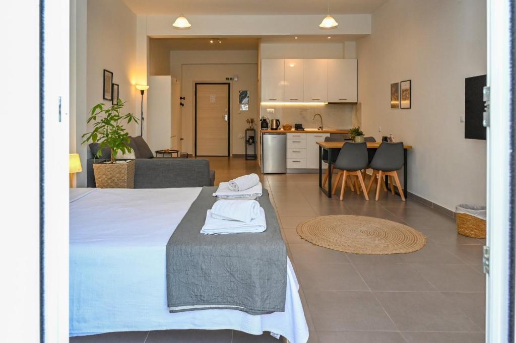 a room with a bed and a living room and a kitchen at Omonoia Central Apartment in Kavála