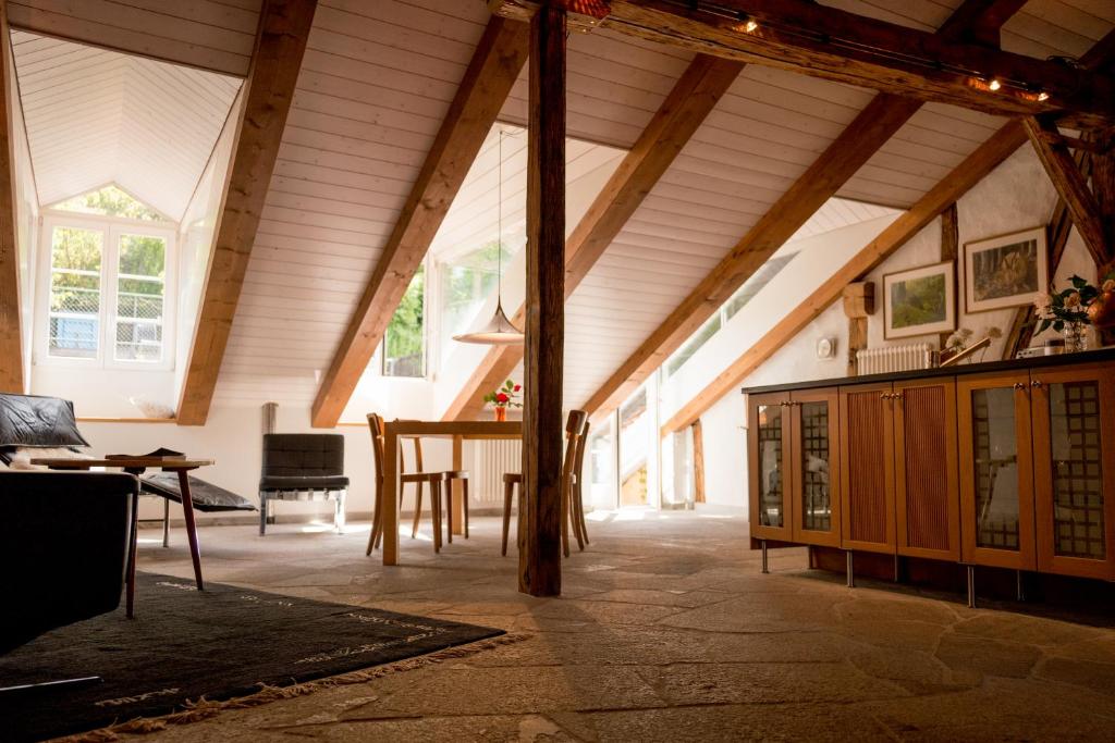 an attic room with a table and a wooden ceiling at Ferienwohnung Schwert in Thun