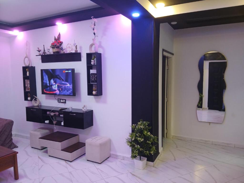 a living room with a tv on a wall at Appartement Saket Plage in Taranimt