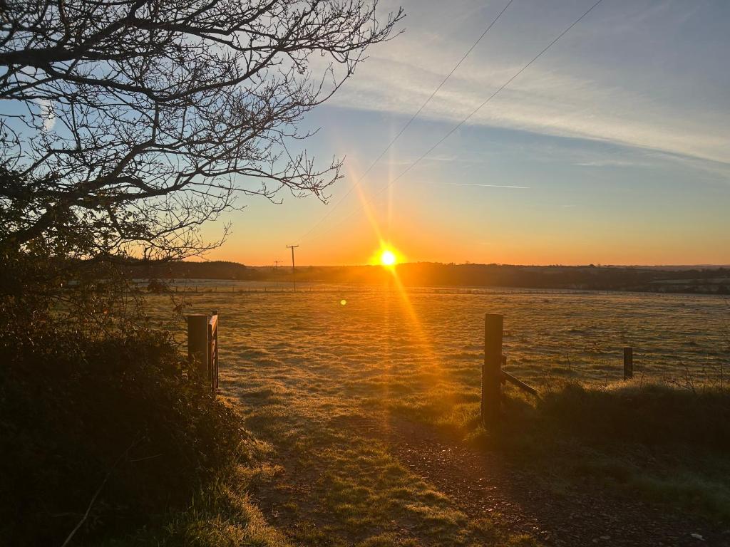 a sun setting over a body of water at Cranford Oak Farm Campsite in Barnstaple