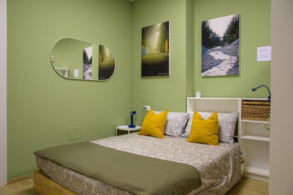 a bedroom with a bed with yellow pillows and a mirror at Open Space Romagna 12 in San Benedetto del Tronto