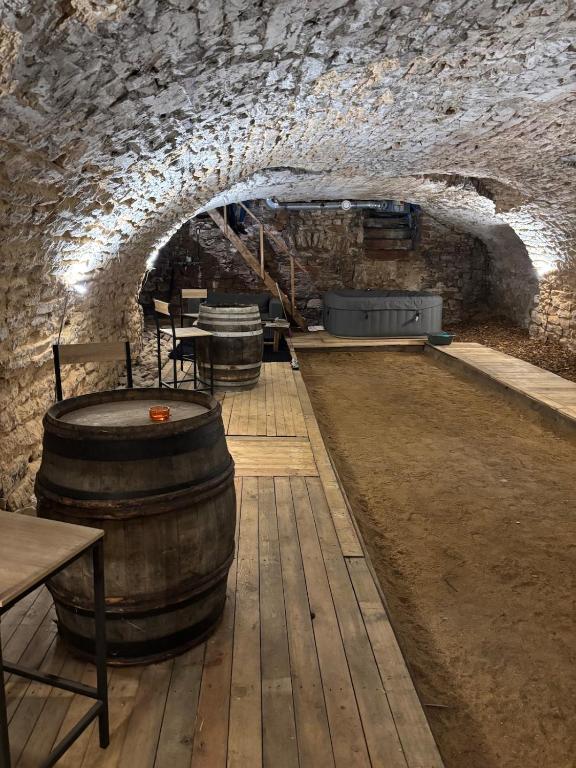 a wine cellar with barrels and tables in a cave at La Cave Des Merveilles in Mâcon