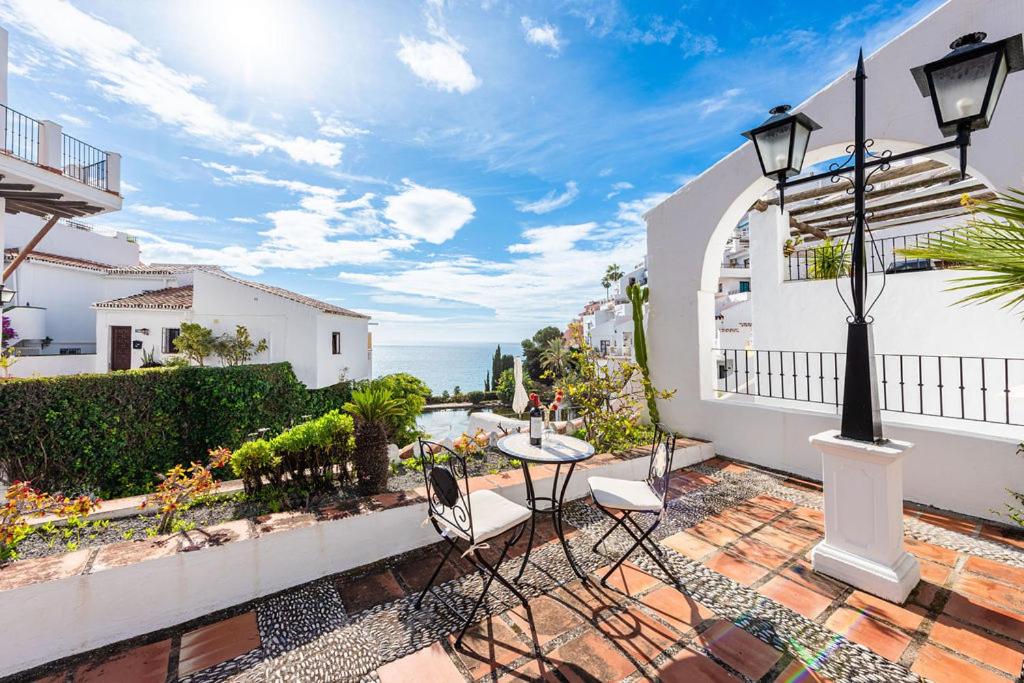 a balcony of a house with a table and chairs at Casa Merlin Capistrano playa in Nerja