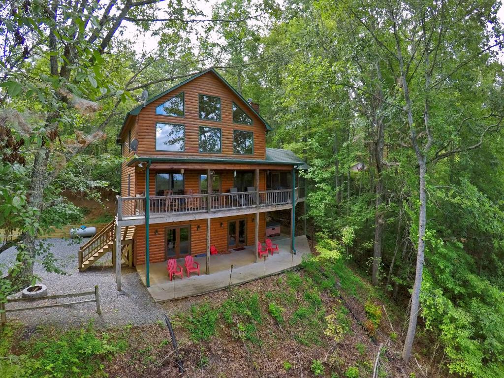 a large wooden house with red chairs in the woods at My Mountain Paradise in Morganton