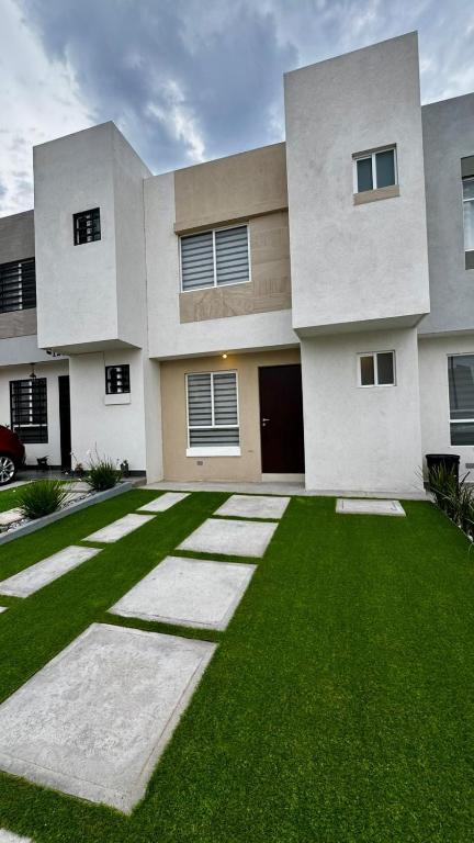 a large house with a green lawn in front of it at Casa completa y equipada in Saucillo de la Joya