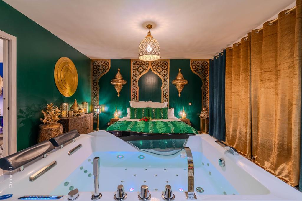 a bath tub in a room with green walls at Suite Riad Luxe avec jacuzzi proche Disney in Nanteuil-lès-Meaux