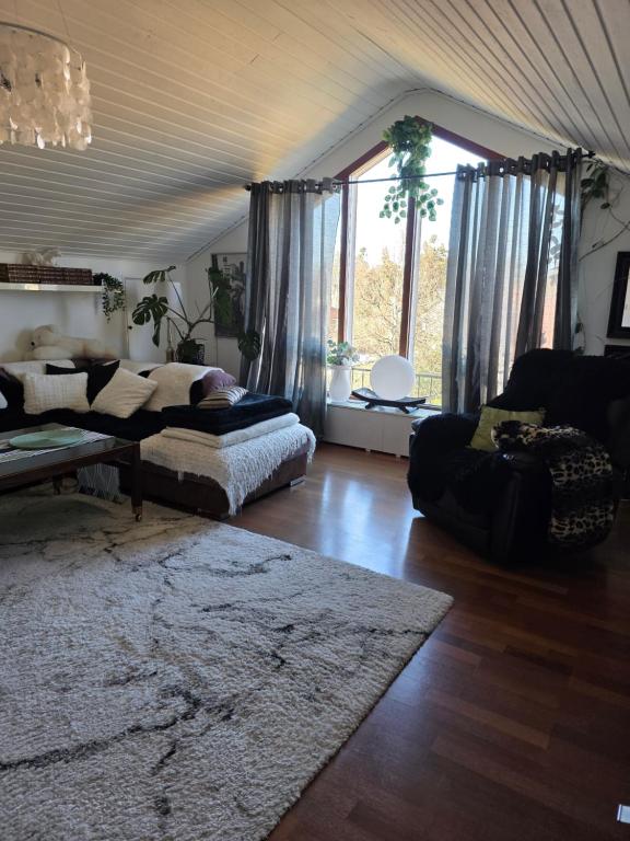 a living room with a couch and a table at Studiolägenhet i villa in Huddinge