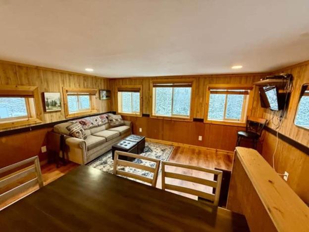 a living room with a couch and a table at Denali Park View Family Log Cabin in Healy