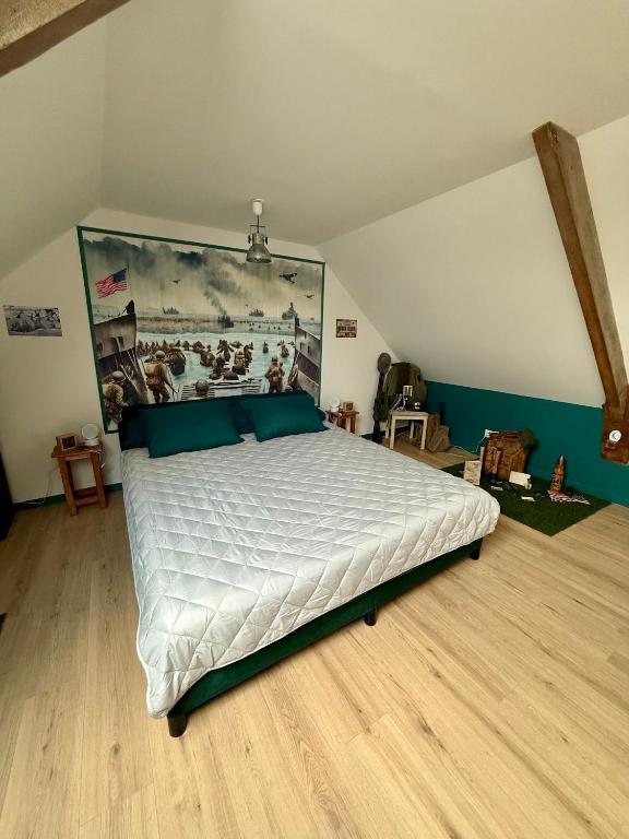 a bedroom with a large bed with a painting on the wall at Comme en 40 in La Lande-sur-Drôme
