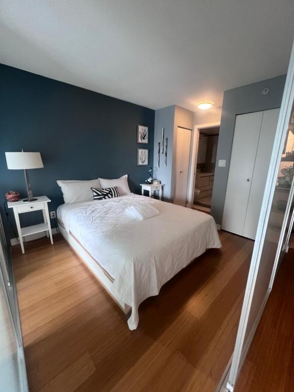 a bedroom with a white bed and a blue wall at Vancouver Condo-Park-Walk to Stadium-Sleeps 4 in Vancouver
