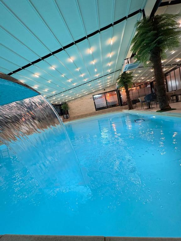 a large blue swimming pool with a water fountain at Skyline Panorama in Vrnjačka Banja