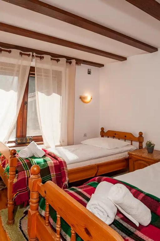 a bedroom with two beds and a window at Вила Соколето in Sokolovtsi