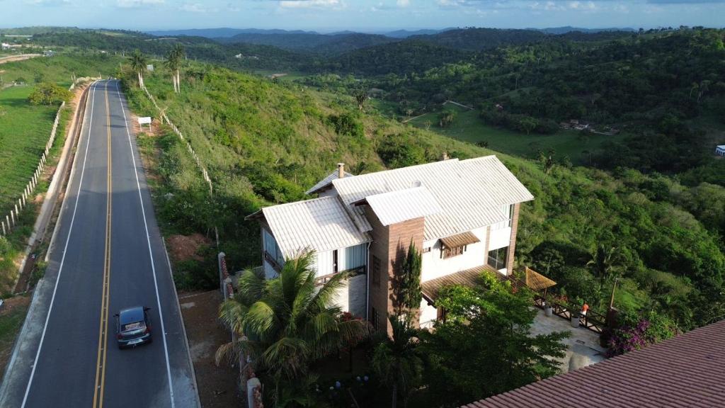 a house on a hill next to a road at A casa do vale in Bananeiras