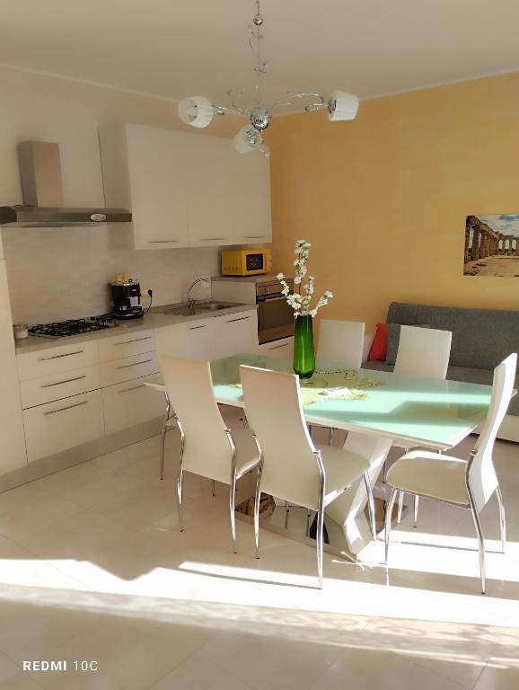 a kitchen with a dining room table and chairs at Casa Doppia G in Oliveri