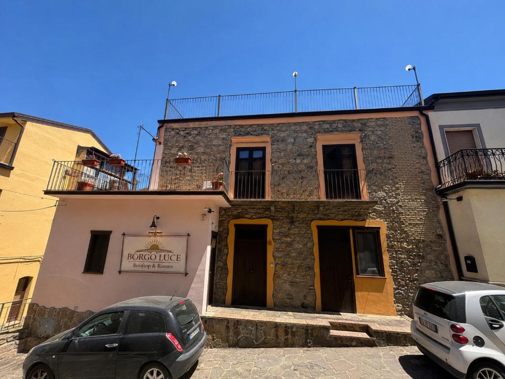 two cars parked in front of a building at Borgo Luce - Rooftop and Rooms in Francavilla Marittima