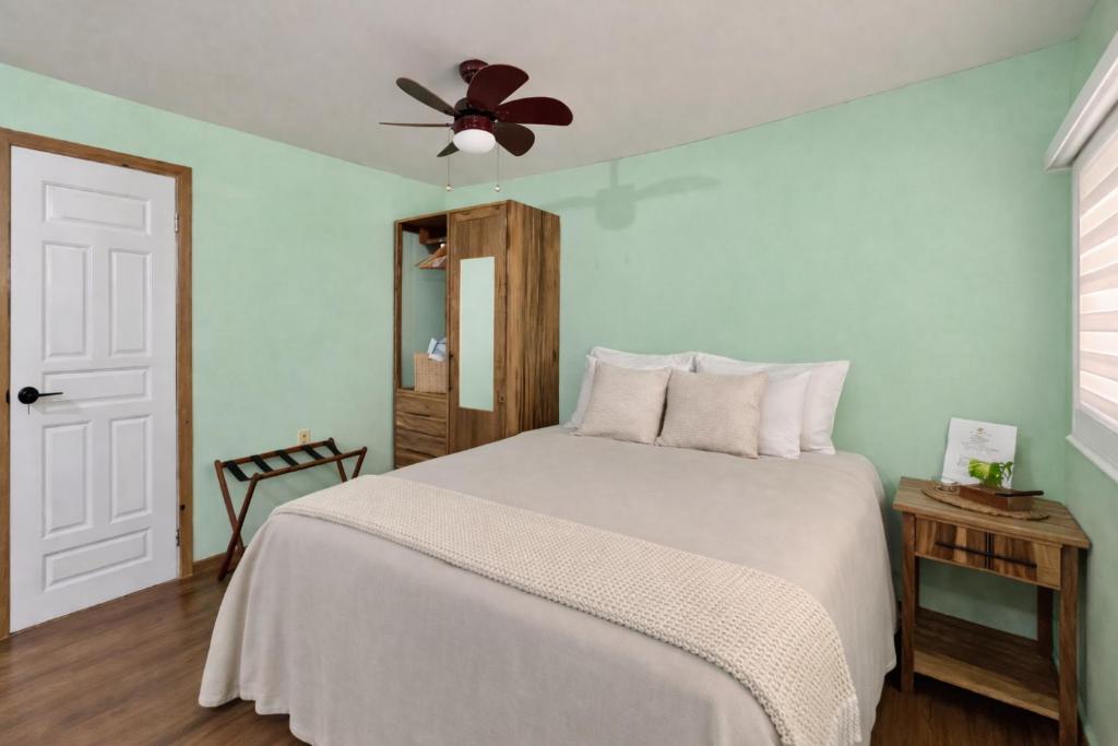 a bedroom with a bed with a ceiling fan at Grace Studio Roatan in Coxen Hole