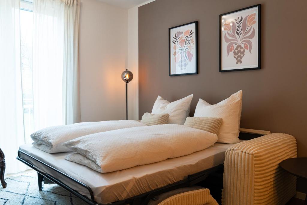 a bedroom with a bed with white sheets and pillows at Neu & modern - hej homes mit kostenfreiem Parken in Bad Kissingen