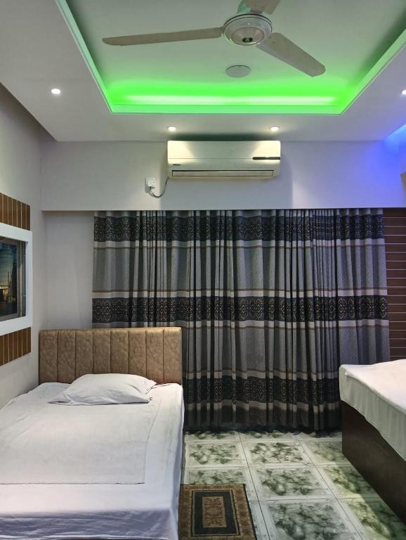 a room with two beds and a green ceiling at Bliss Spa Gulshan - Spa in Gulshan in Bhola