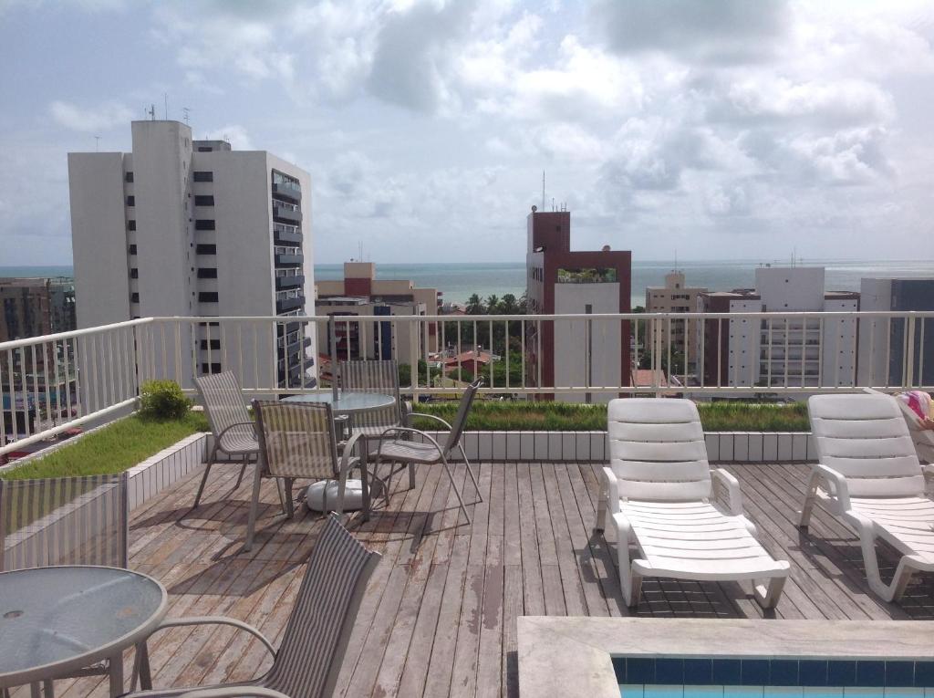 balcón con sillas y mesas y vistas a la ciudad en Apartamento Água Azul, en João Pessoa