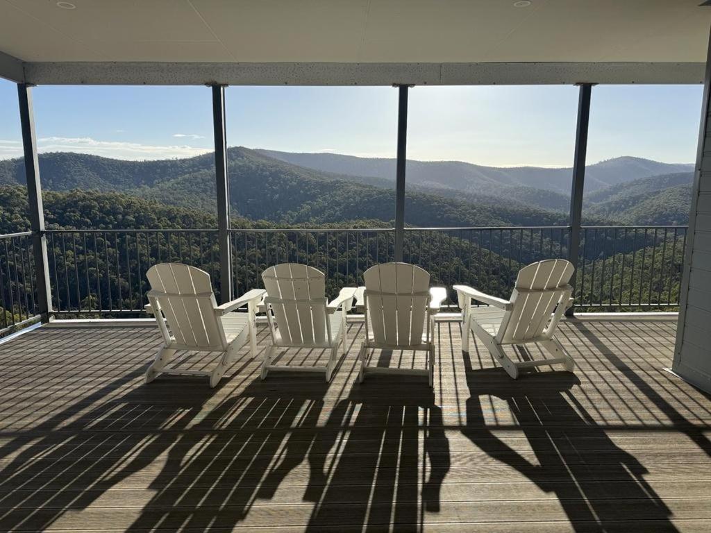 a group of chairs sitting on a deck with a view at Golden Valley - Steels Creek in Steels Creek