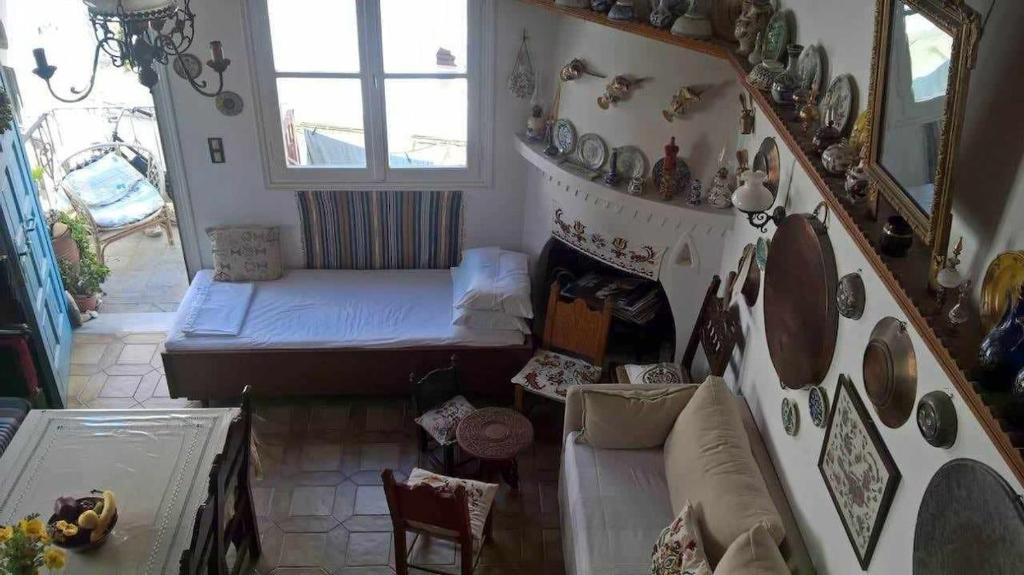 a living room with a couch and a stair case at Myrto's traditional house in Skiros