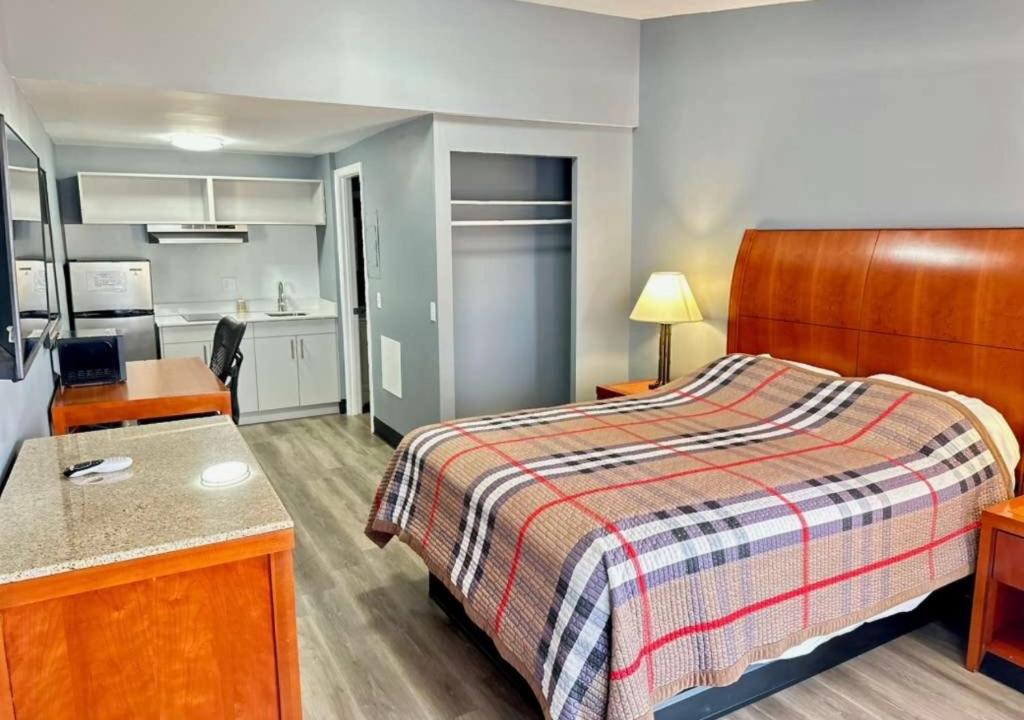 a hotel room with a bed and a kitchen at Sunwestern Suites in Douglasville