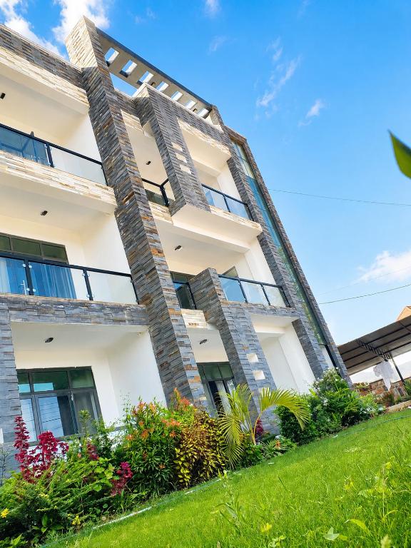 a large white building with plants in front of it at Kigali Clever Homes Villa in Kigali