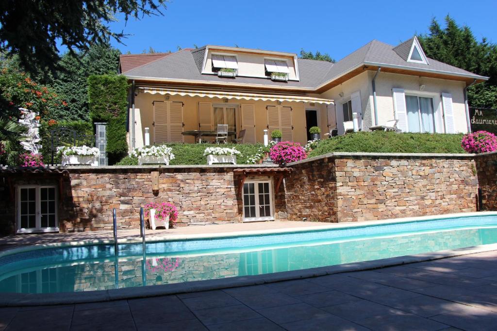 a house with a swimming pool in front of a house at Ma chaumiere in Les Cammazes