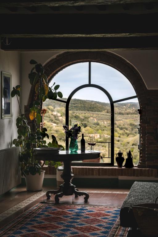 a room with a table in front of a large window at Casa Marelli in Castelmuzio